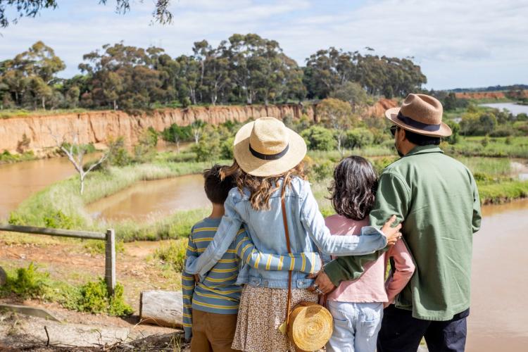 two adults and two children looking towards K Road Cliffs and the Werribee River